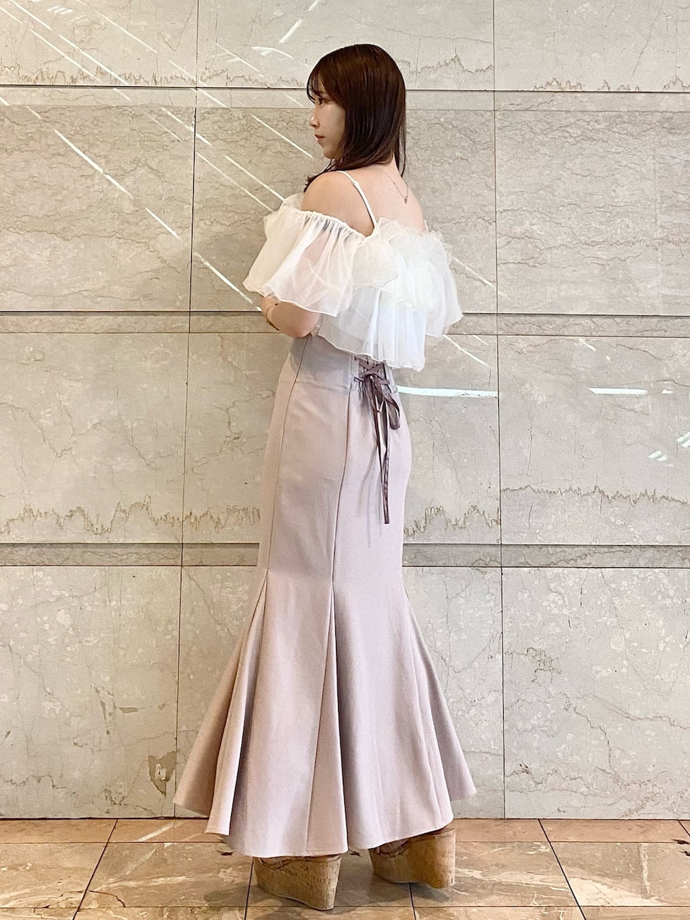 ピンク系のスカート、ホワイト系のシャツ/ブラウス、その他のサンダルを着用したレディースの夏コーディネートの2枚目の写真