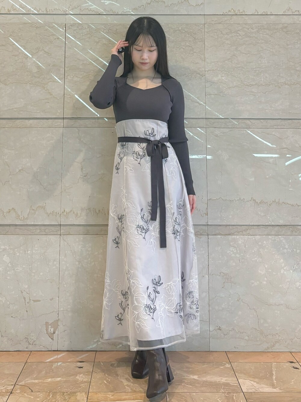 ベージュ系のワンピース、ブラウン系のブーツを着用したレディースの秋コーディネートの2枚目の写真