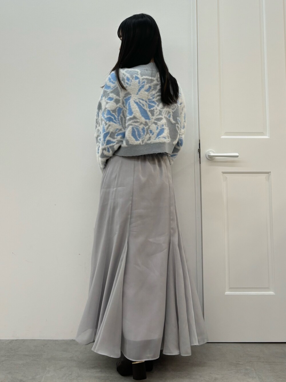 ブルー系のニット/セーター、ブラウン系のブーツ、グレー系のスカートを着用したレディースの秋コーディネートの5枚目の写真