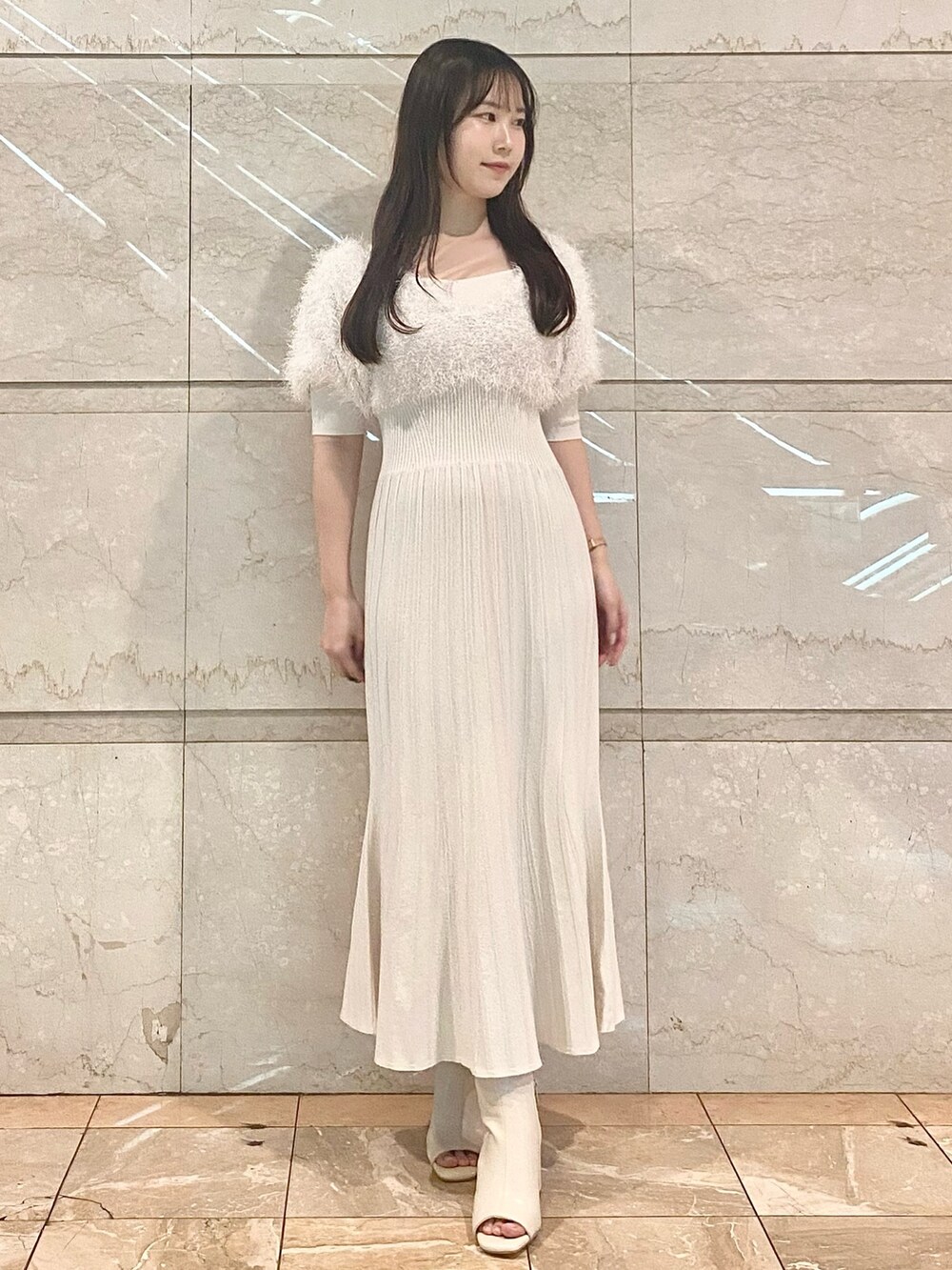 ホワイト系のワンピース、ホワイト系のブーツを着用したレディースの冬コーディネートの2枚目の写真
