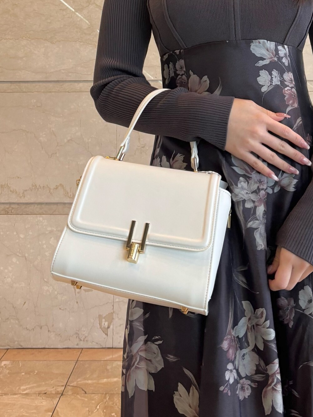 ホワイト系のハンドバッグ、ホワイト系のパンプス、グレー系のワンピースを着用したレディースの春コーディネートの3枚目の写真