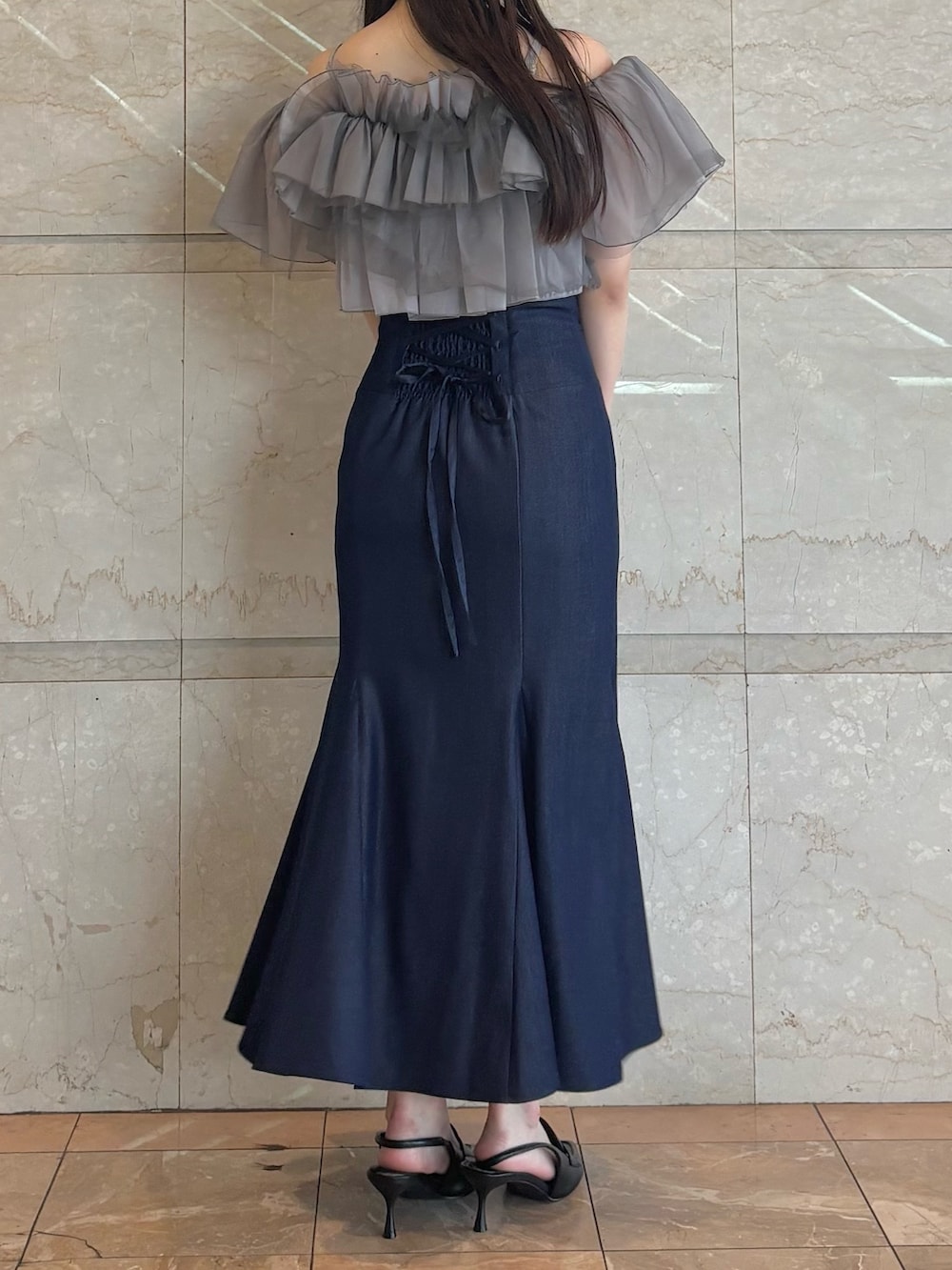 ブルー系のスカート、ブラック系のパンプス、グレー系のシャツ/ブラウスを着用したレディースの夏コーディネートの4枚目の写真