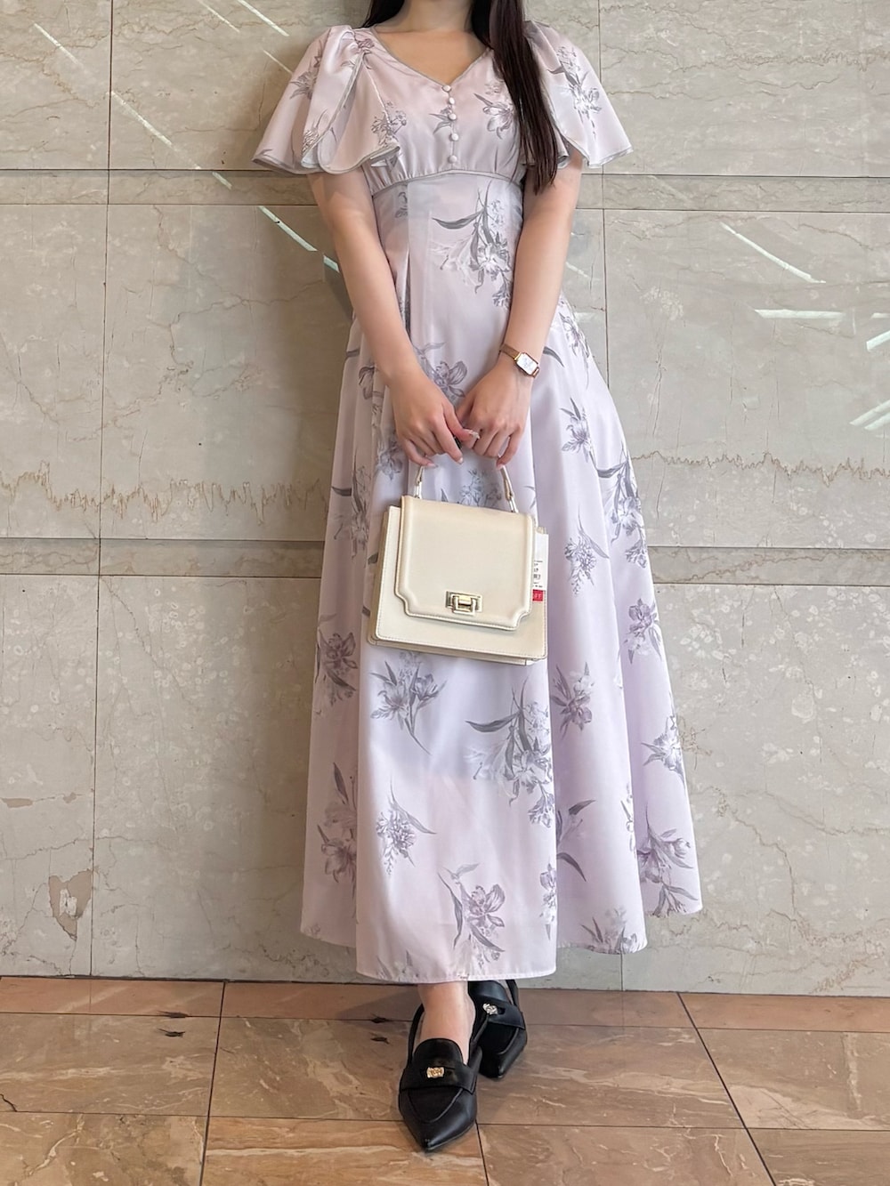 ホワイト系のハンドバッグ、ピンク系のワンピース、ブラック系のパンプスを着用したレディースの夏コーディネートの2枚目の写真