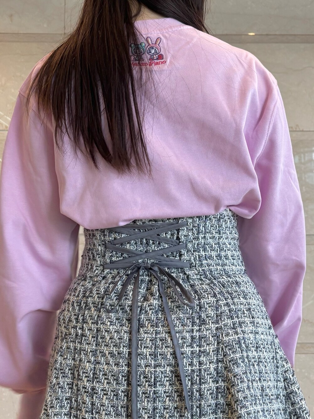 ブラック系のスカート、ホワイト系のブーツ、ピンク系のTシャツ/カットソーを着用したレディースの冬コーディネートの8枚目の写真