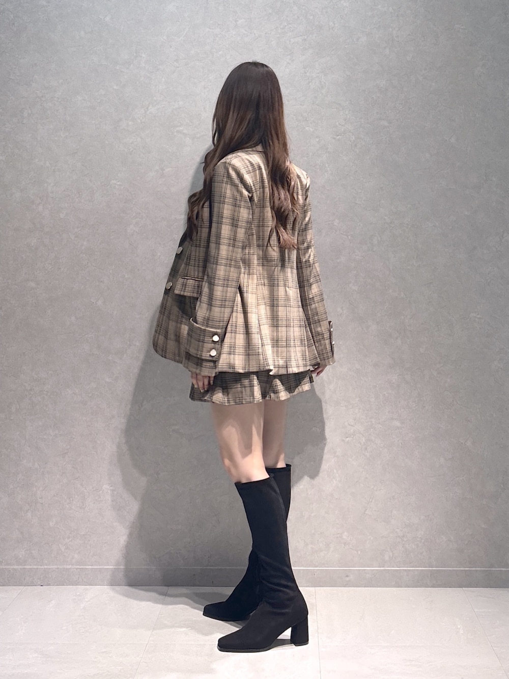 ベージュ系のスカート、ブラック系のブーツ、ブラウン系のTシャツ/カットソーを着用したレディースの秋コーディネートの3枚目の写真