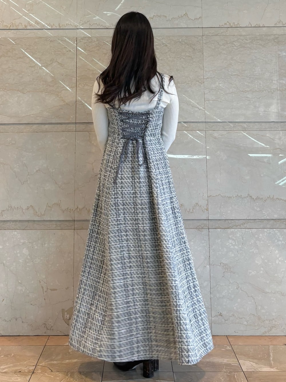 ブラック系のワンピース、ブラック系のブーツ、ホワイト系のニット/セーターを着用したレディースの冬コーディネートの3枚目の写真