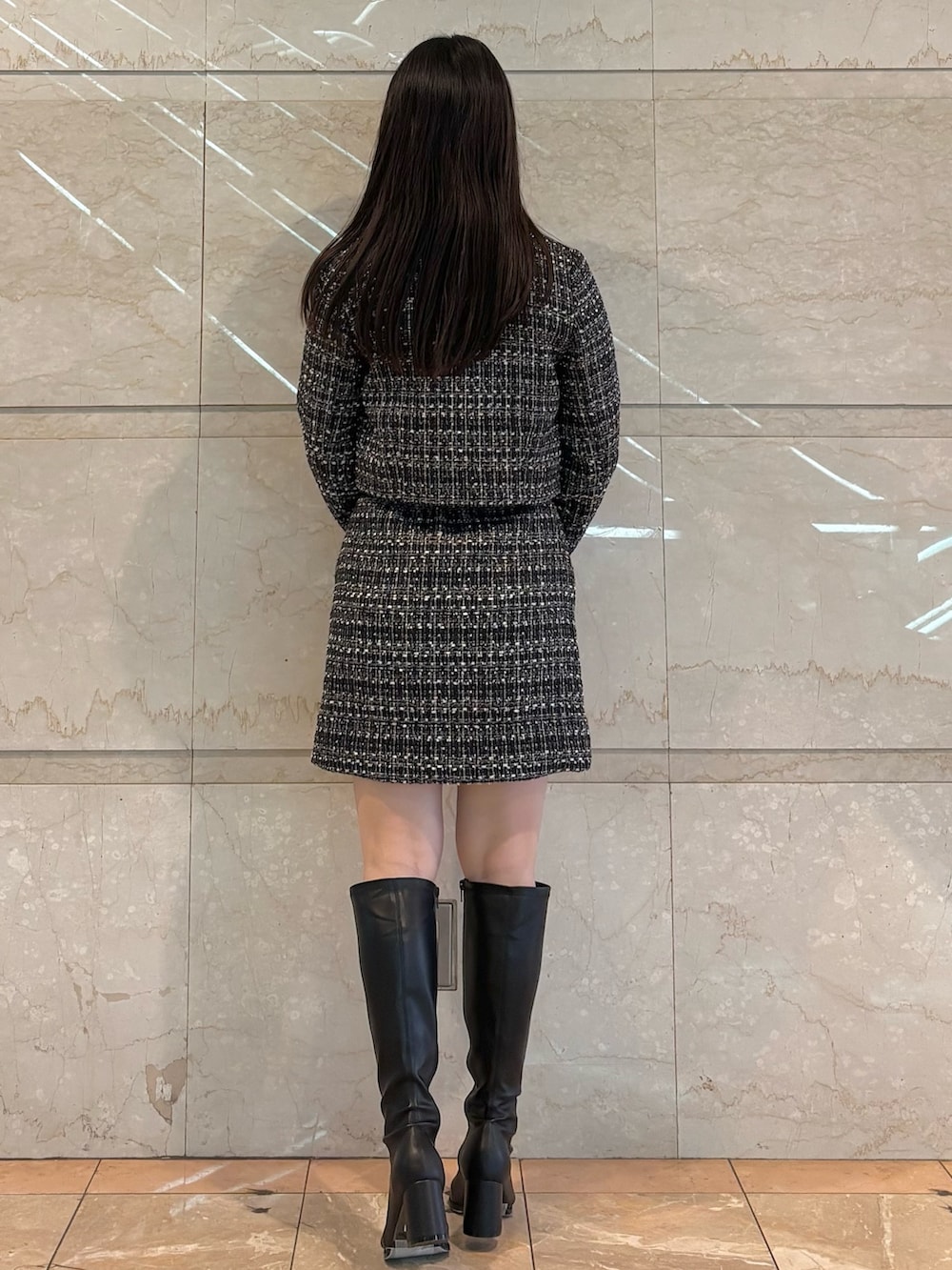 ブラック系のスカート、ブラック系のテーラードジャケット、ブラウン系のブーツを着用したレディースの冬コーディネートの4枚目の写真