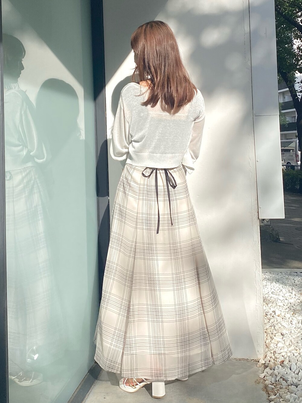 ブラック系のワンピース、ホワイト系のサンダル、ホワイト系のカーディガン/ボレロを着用したレディースの夏コーディネートの2枚目の写真