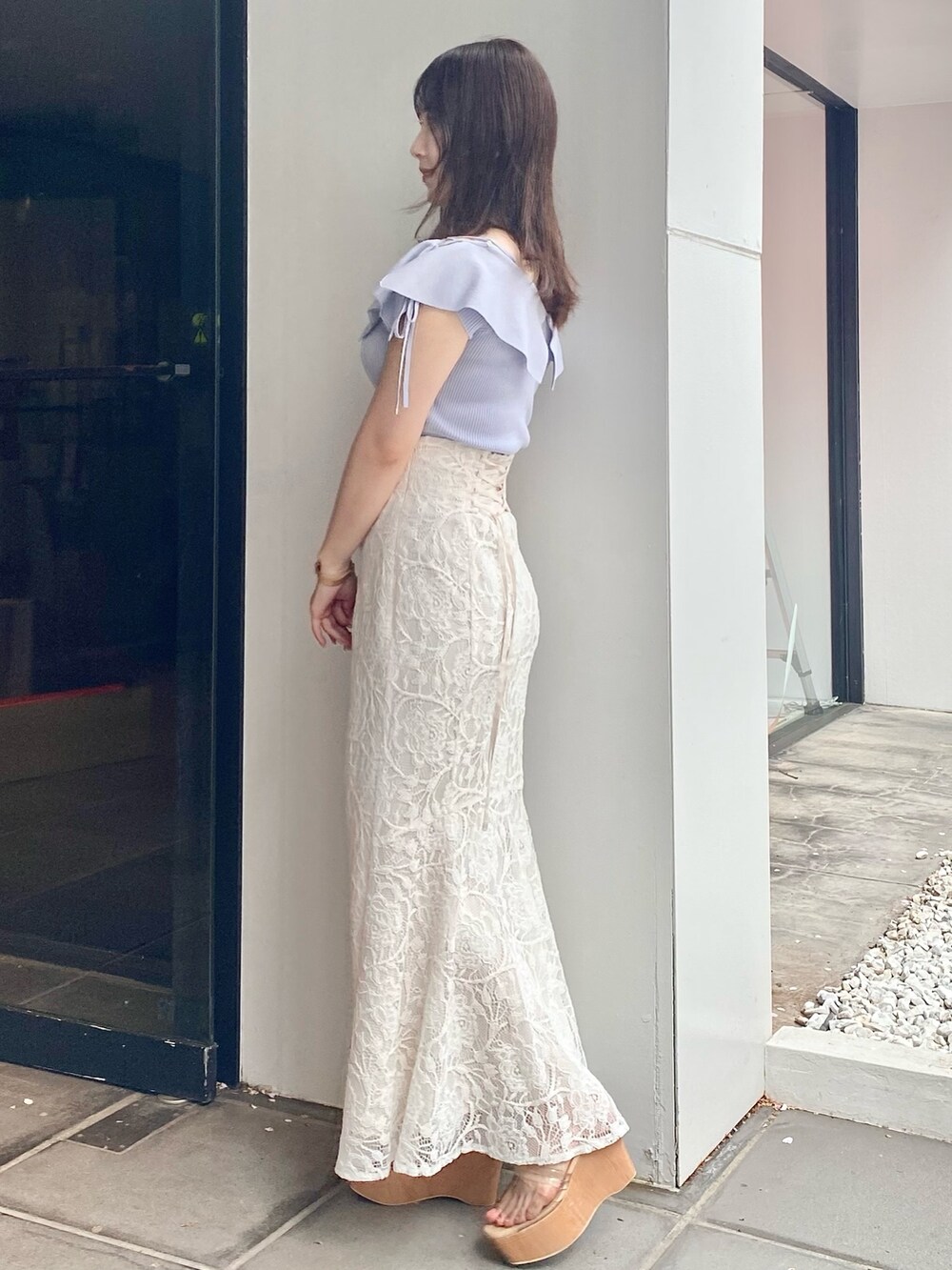 ホワイト系のスカート、グレー系のサンダル、ブルー系のニット/セーターを着用したレディースの春コーディネートの3枚目の写真