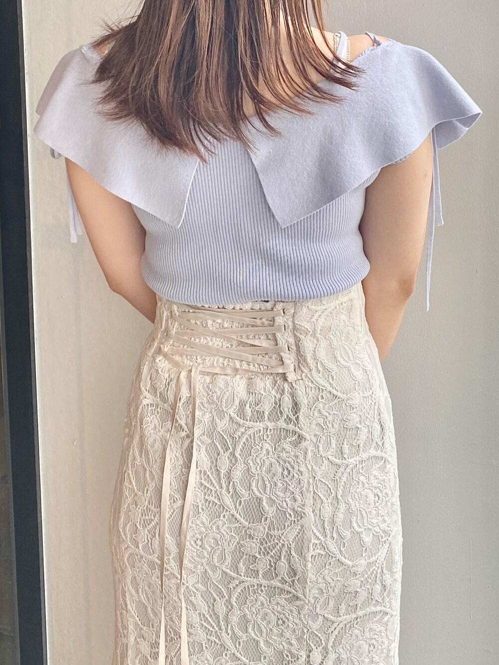 ホワイト系のスカート、グレー系のサンダル、ブルー系のニット/セーターを着用したレディースの春コーディネートの5枚目の写真