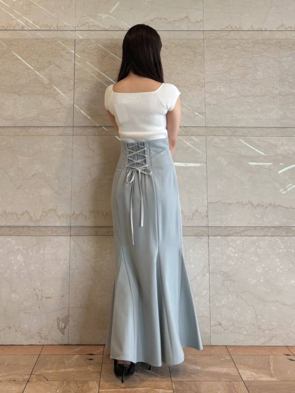 ブラック系のパンプス、ブルー系のスカート、ホワイト系のニット/セーターを着用したレディースの夏コーディネートの5枚目の写真