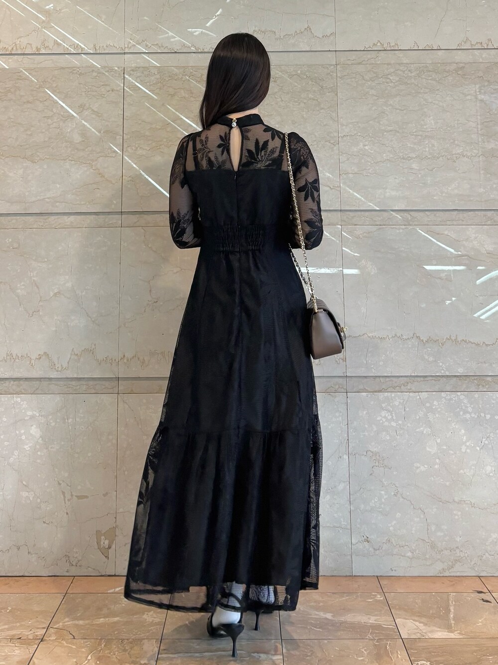 ブラウン系のハンドバッグ、ブラック系のパンプス、ブラック系のワンピースを着用したレディースの冬コーディネートの4枚目の写真