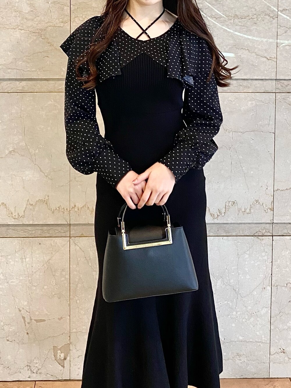 ブラック系のワンピース、ブラック系のブーツ、ブラック系のハンドバッグを着用したレディースの秋コーディネートの5枚目の写真