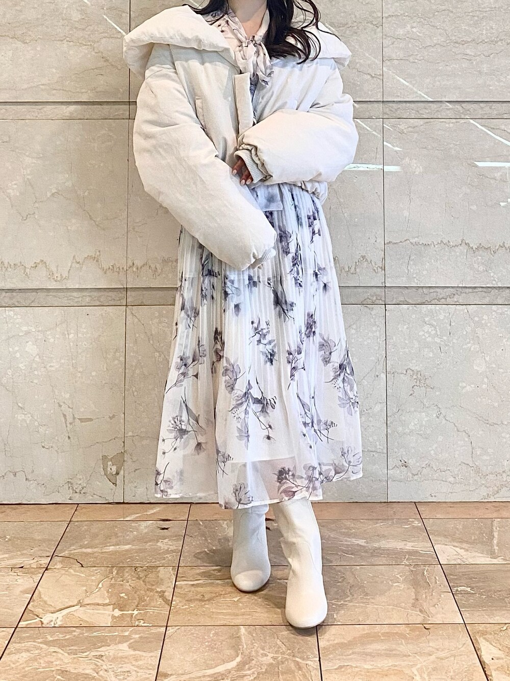 ピンク系のワンピース、ホワイト系のダウンジャケット/コート、ホワイト系のブーツを着用したレディースの冬コーディネートの2枚目の写真