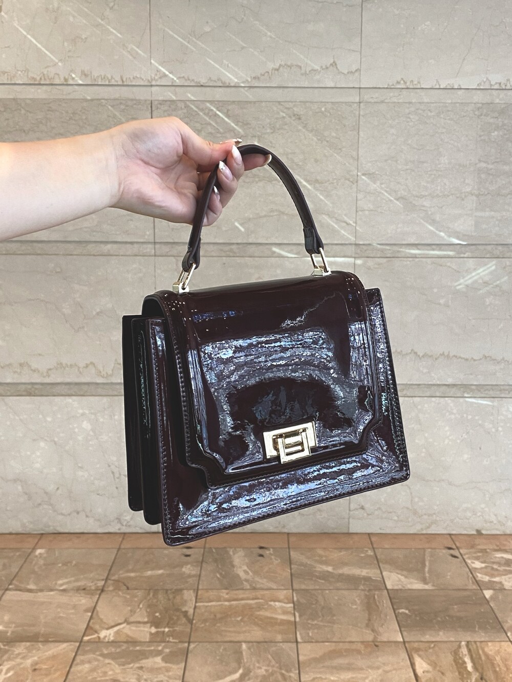 ベージュ系のワンピース、レッド系のハンドバッグ、ホワイト系のブーツを着用したレディースの夏コーディネートの5枚目の写真