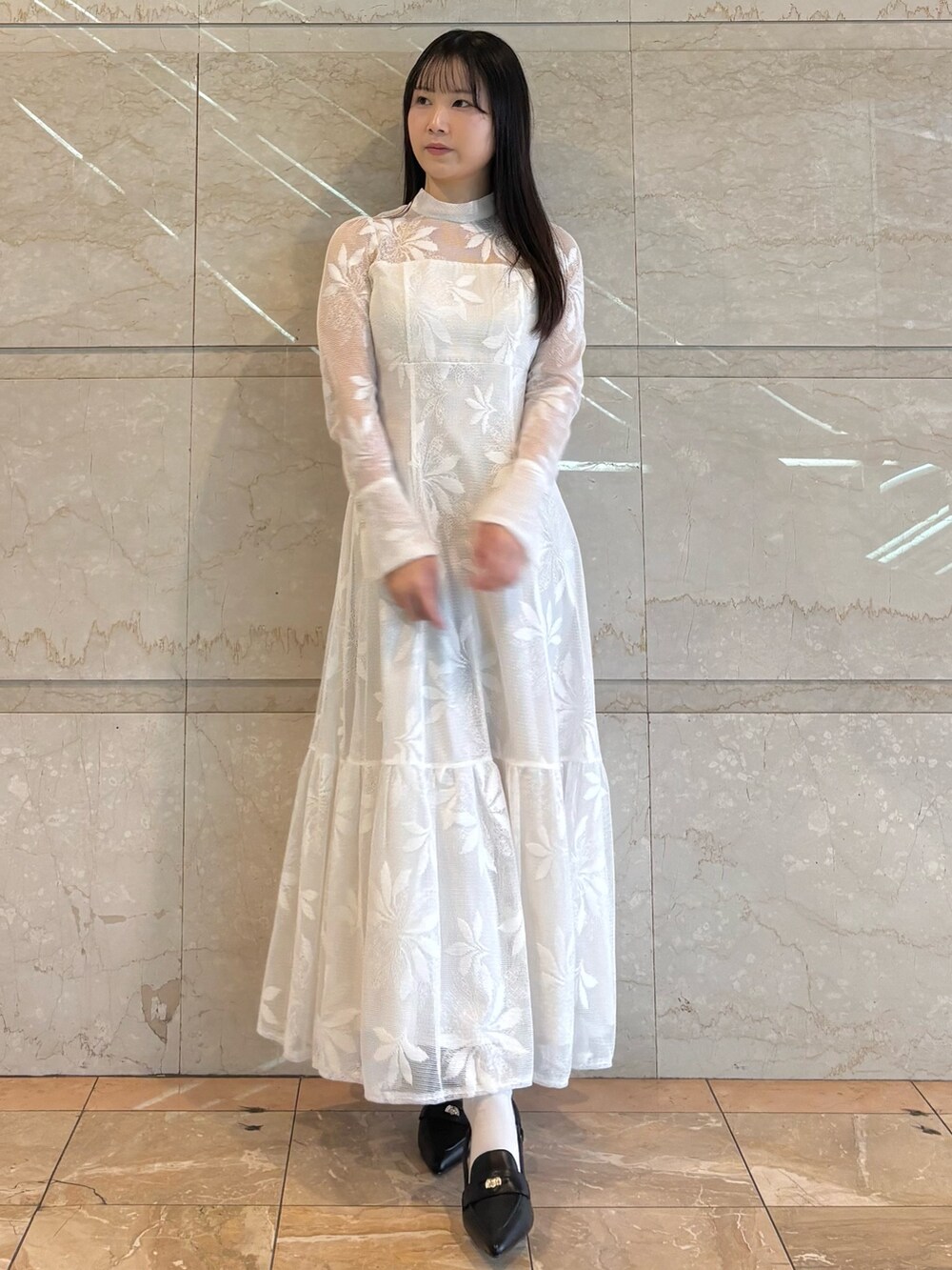 ホワイト系のワンピース、ブラック系のパンプスを着用したレディースの冬コーディネートの3枚目の写真