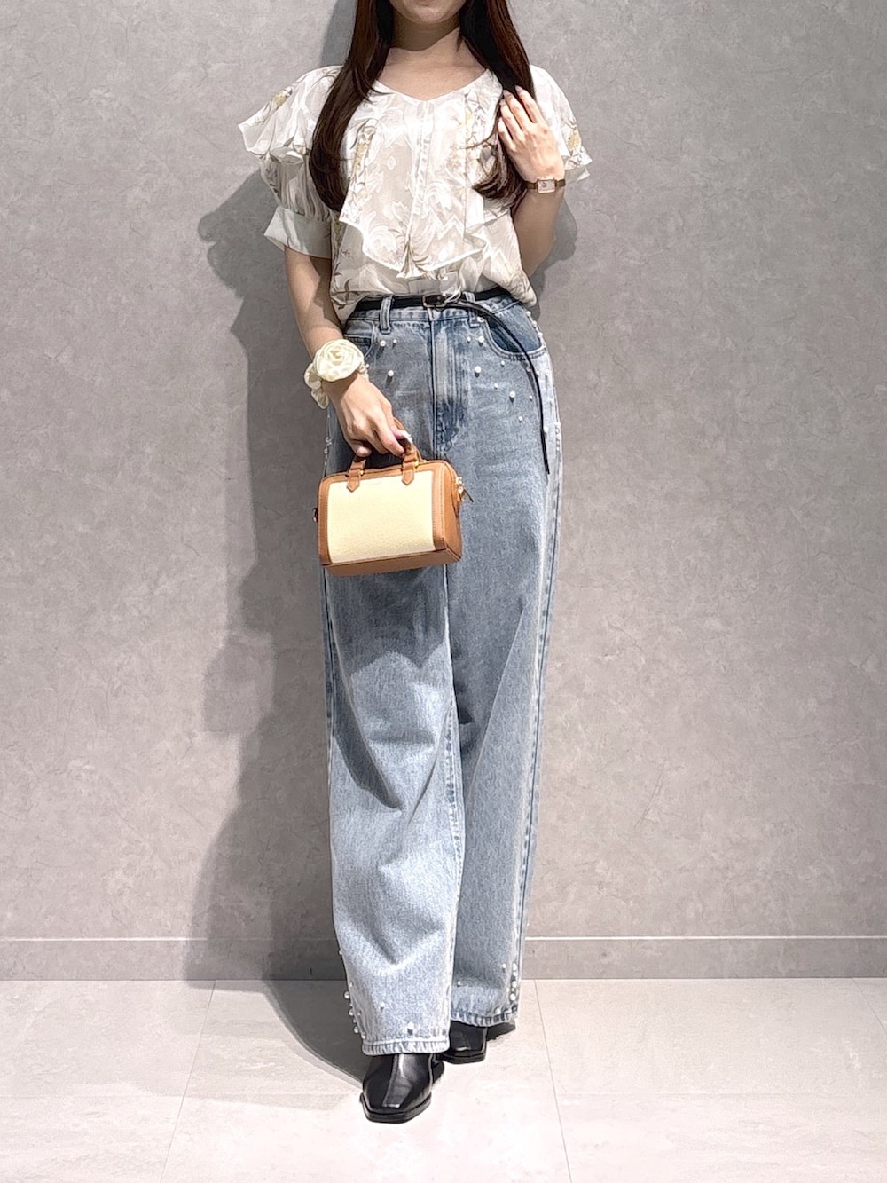 ホワイト系のシャツ/ブラウス、ブラウン系のハンドバッグ、ブルー系のデニムパンツを着用したレディースの秋コーディネートの3枚目の写真