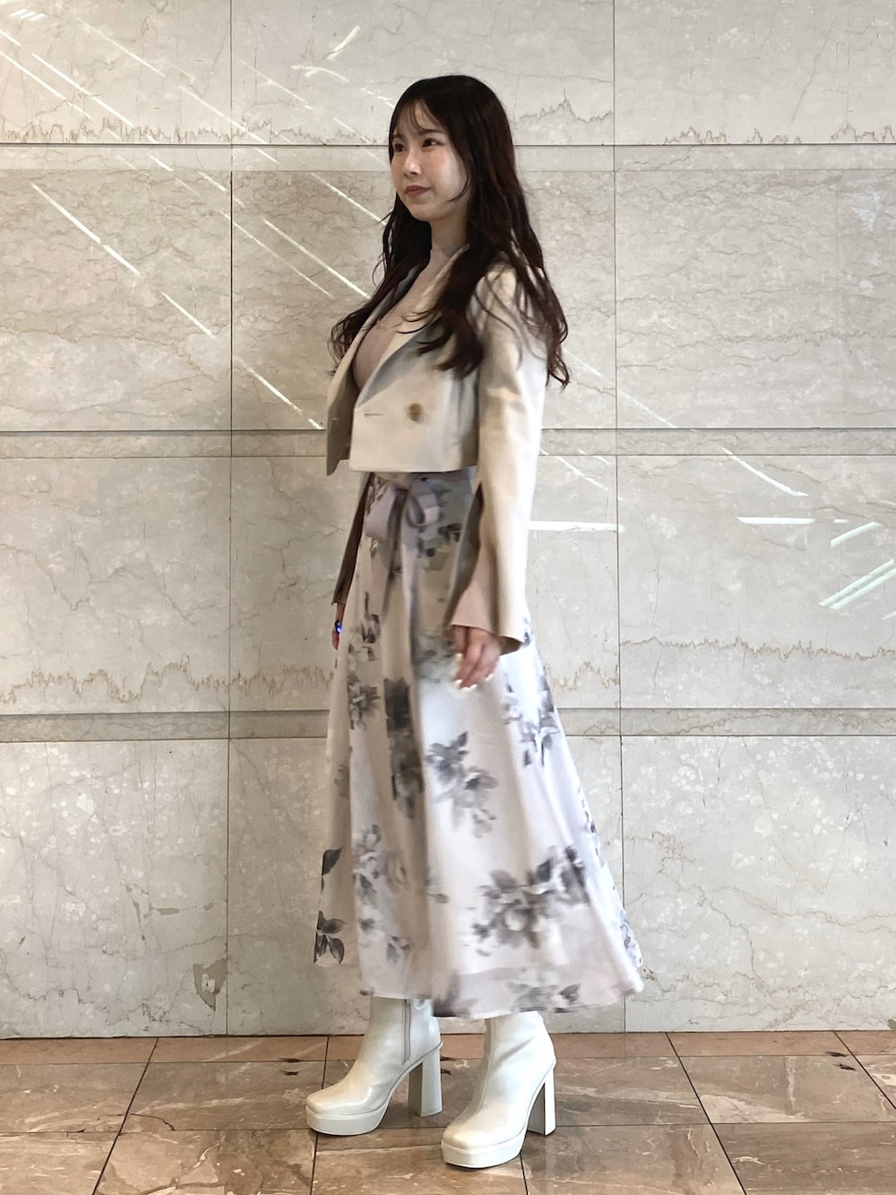 ベージュ系のワンピース、ホワイト系のブーツ、ベージュ系のテーラードジャケットを着用したレディースの秋コーディネートの2枚目の写真
