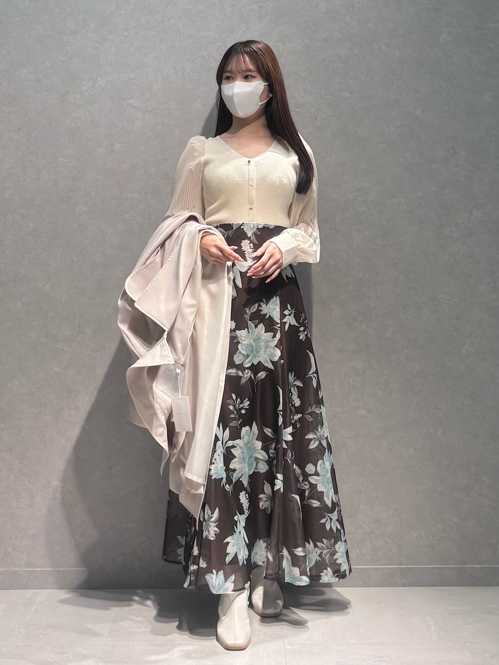 ブラウン系のスカート、ホワイト系のニット/セーター、ホワイト系のトレンチコートを着用したレディースの春コーディネートの5枚目の写真