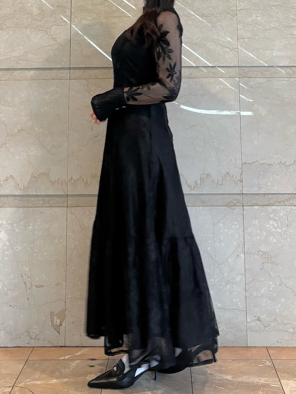 ブラウン系のハンドバッグ、ブラック系のパンプス、ブラック系のワンピースを着用したレディースの冬コーディネートの3枚目の写真