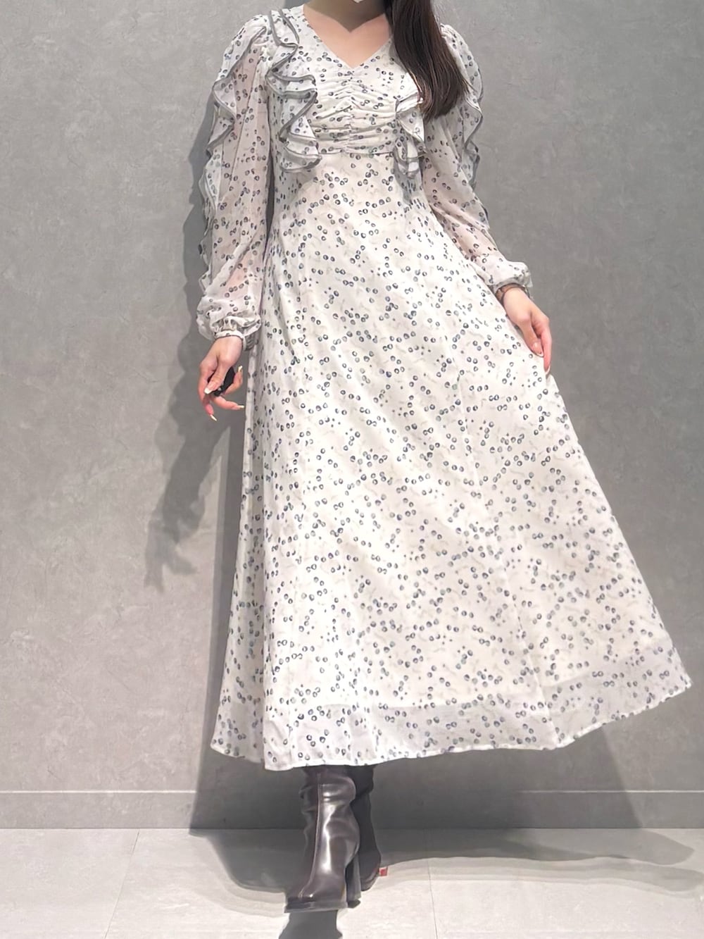 ホワイト系のワンピース、ブラウン系のブーツを着用したレディースの冬コーディネートの2枚目の写真