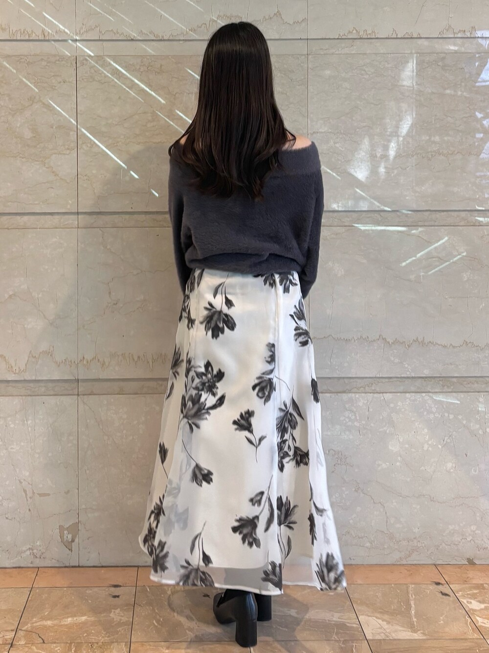 ホワイト系のスカート、ブラック系のブーツ、グレー系のニット/セーターを着用したレディースの冬コーディネートの3枚目の写真