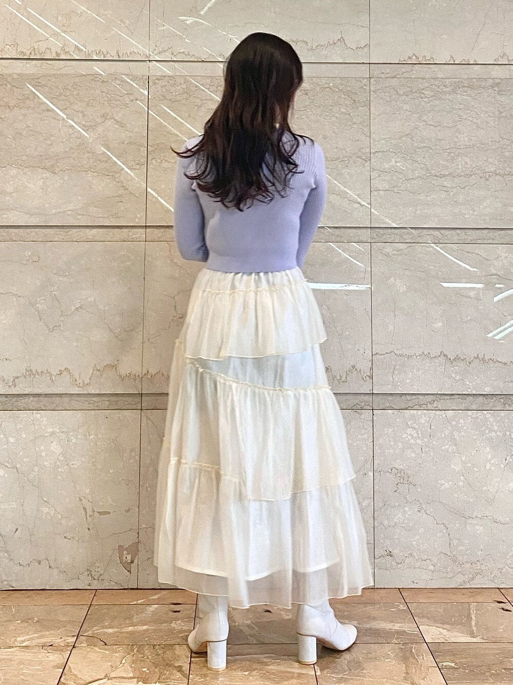 ブルー系のカーディガン/ボレロ、ホワイト系のスカート、ホワイト系のブーツを着用したレディースの冬コーディネートの3枚目の写真