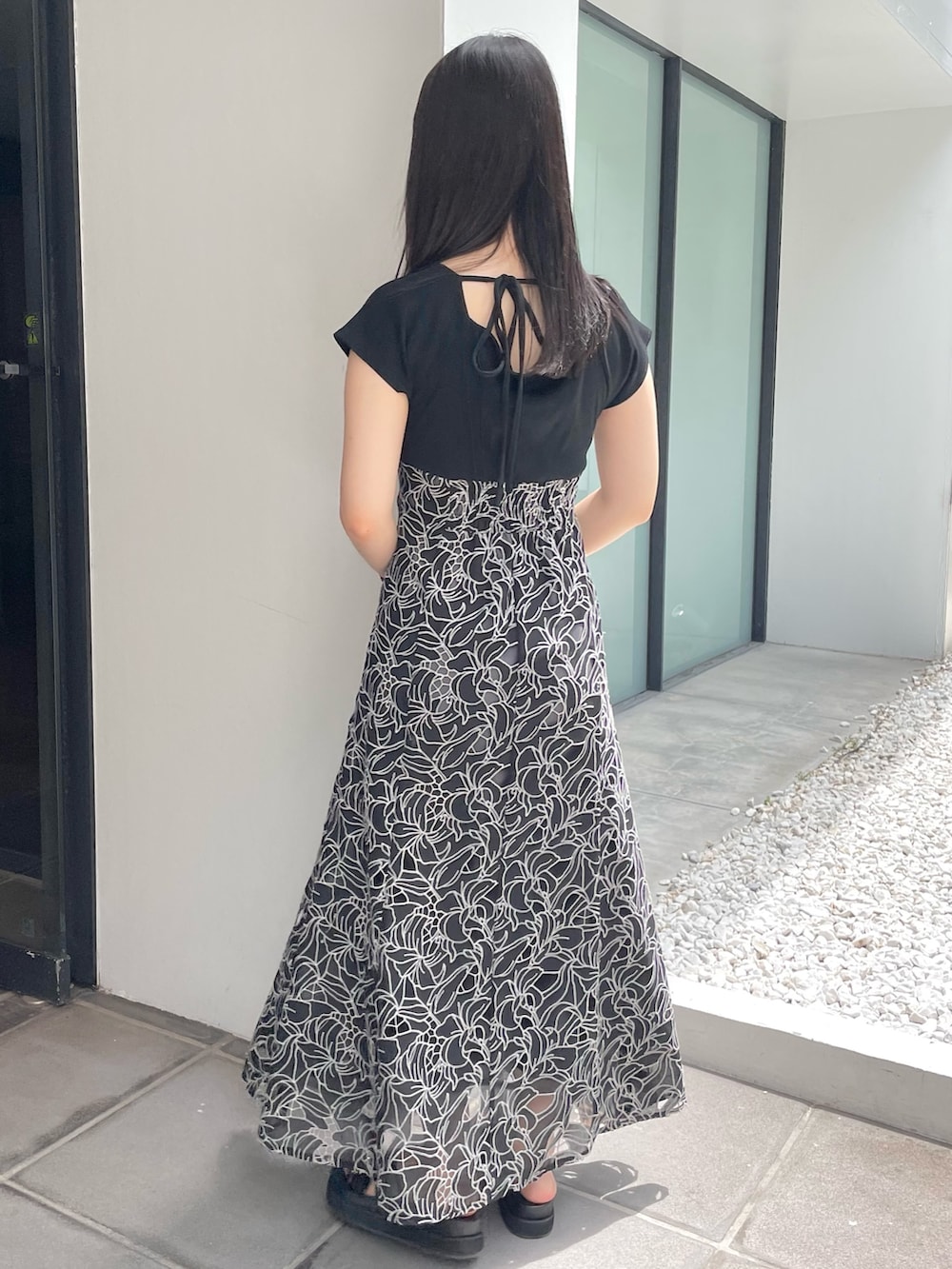 ブラック系のサンダル、ブラック系のワンピースを着用したレディースの夏コーディネートの3枚目の写真