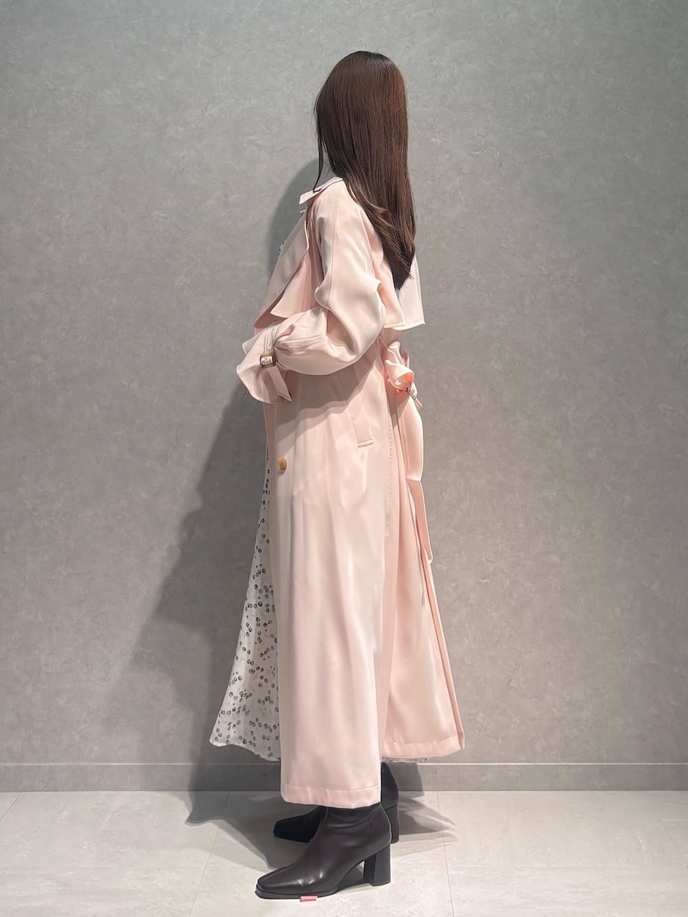 ホワイト系のワンピース、ピンク系のトレンチコート、ブラウン系のブーツを着用したレディースの春コーディネートの4枚目の写真