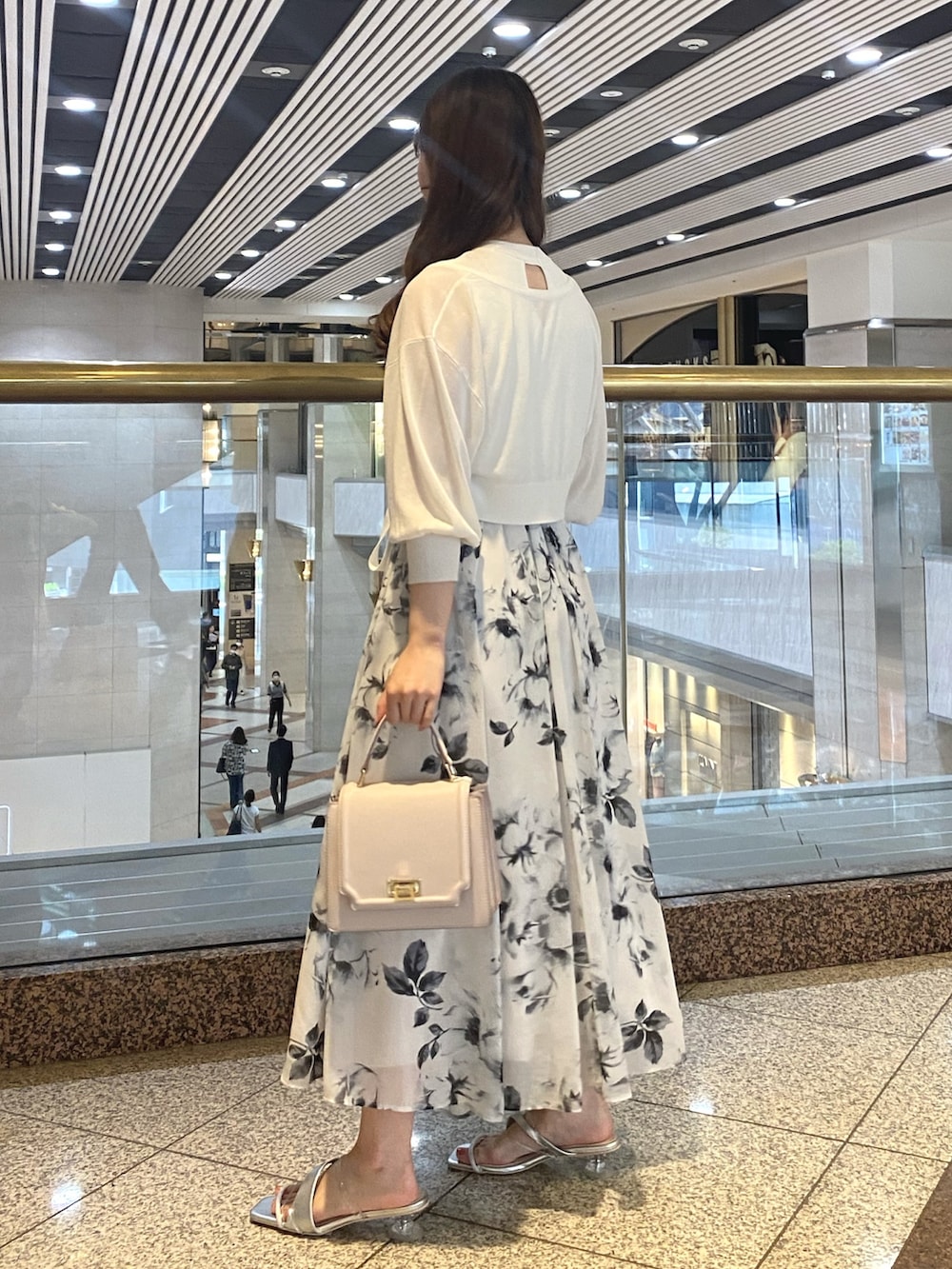 ホワイト系のワンピース、シルバー系のサンダル、ホワイト系のカーディガン/ボレロを着用したレディースの夏コーディネートの6枚目の写真