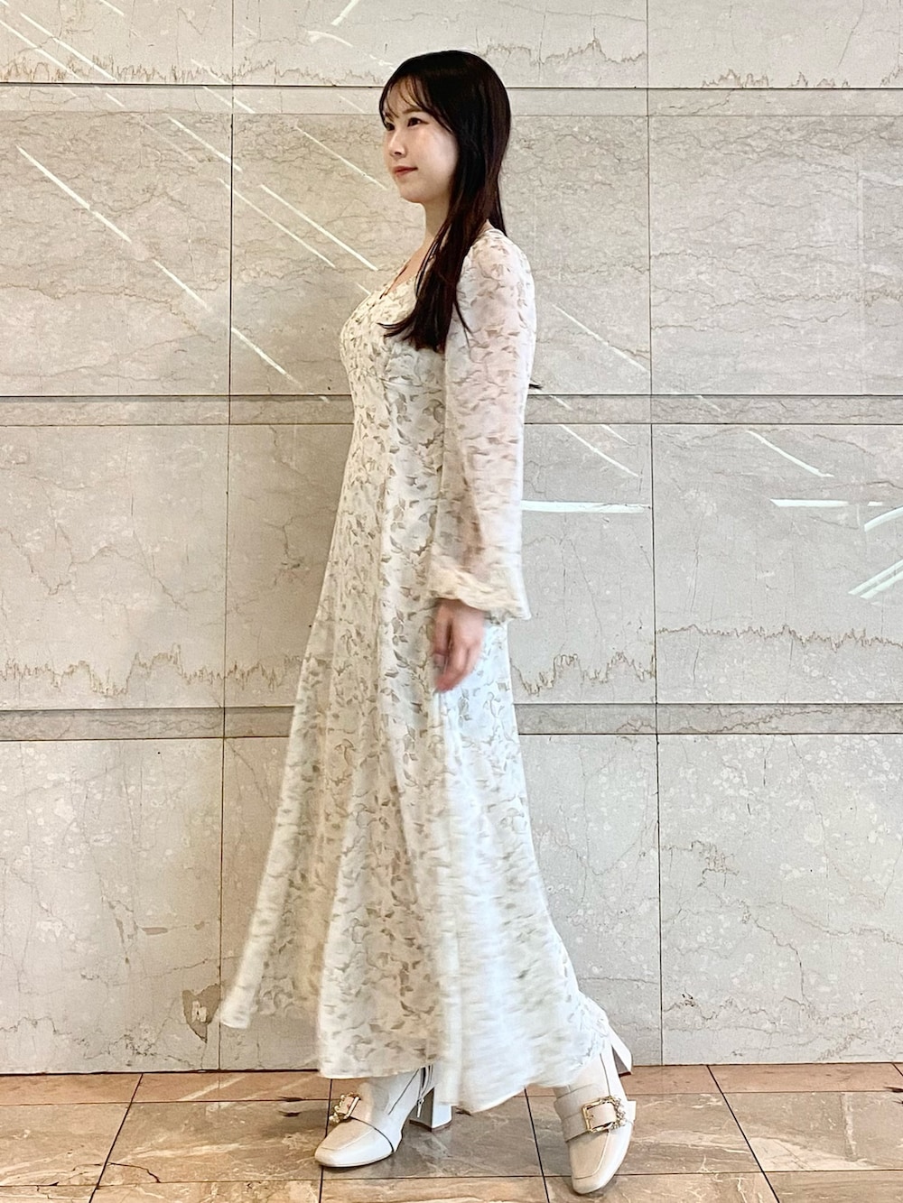 ホワイト系のワンピース、ホワイト系のブーツを着用したレディースの冬コーディネートの3枚目の写真