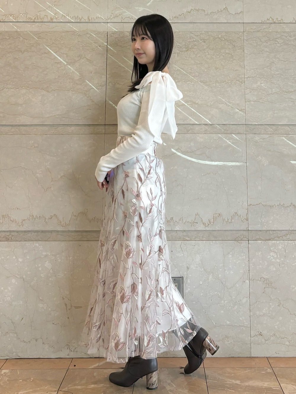 ホワイト系のスカート、ブラウン系のブーツ、ホワイト系のニット/セーターを着用したレディースの秋コーディネートの2枚目の写真