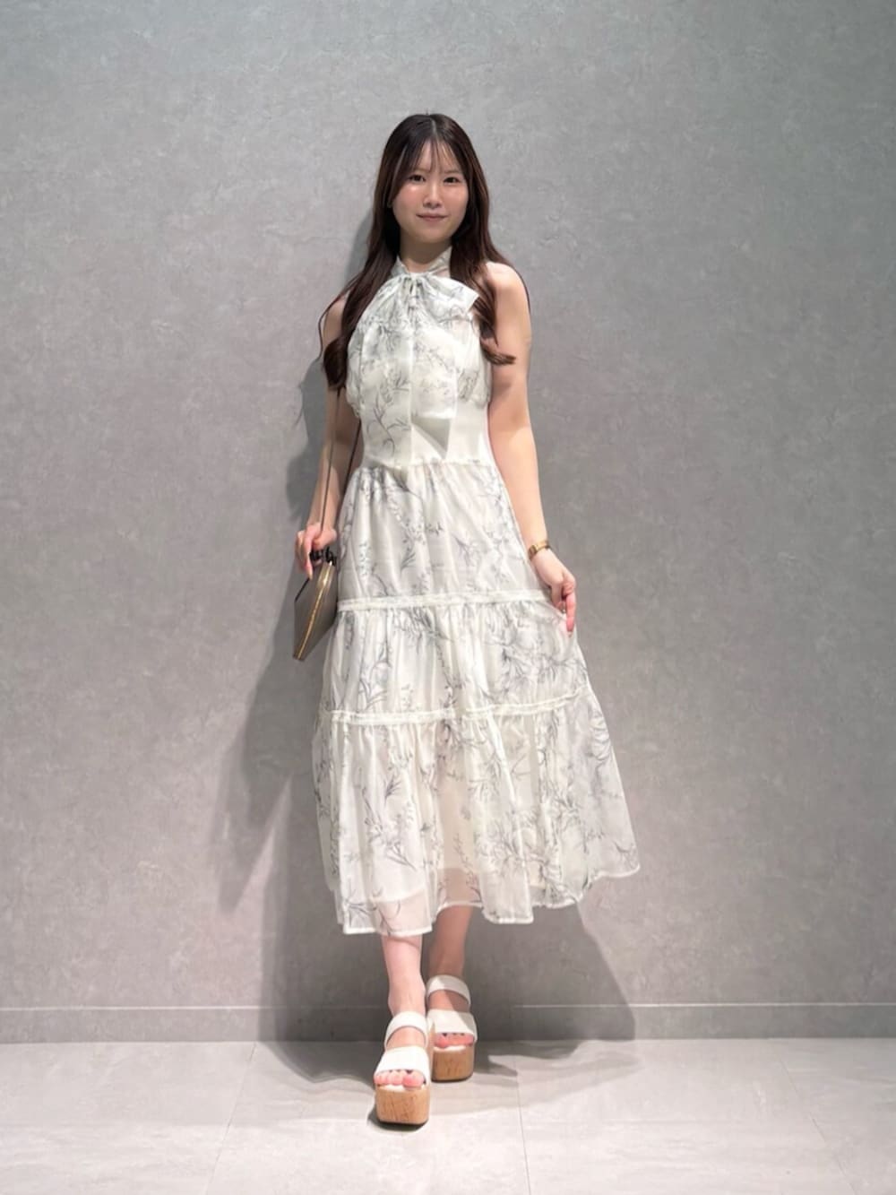 ベージュ系のショルダーバッグ、ホワイト系のサンダル、ホワイト系のワンピースを着用したレディースの夏コーディネートの3枚目の写真