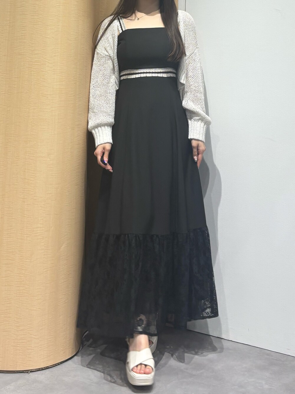 ブラック系のワンピース、ホワイト系のサンダル、ホワイト系のカーディガン/ボレロを着用したレディースの夏コーディネートの3枚目の写真