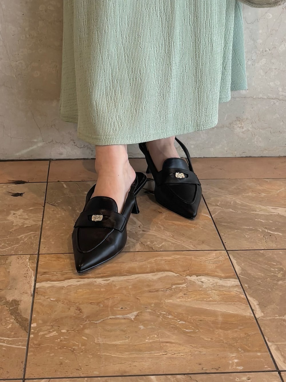 グリーン系のワンピース、ブラック系のパンプス、ホワイト系のショルダーバッグを着用したレディースの夏コーディネートの6枚目の写真