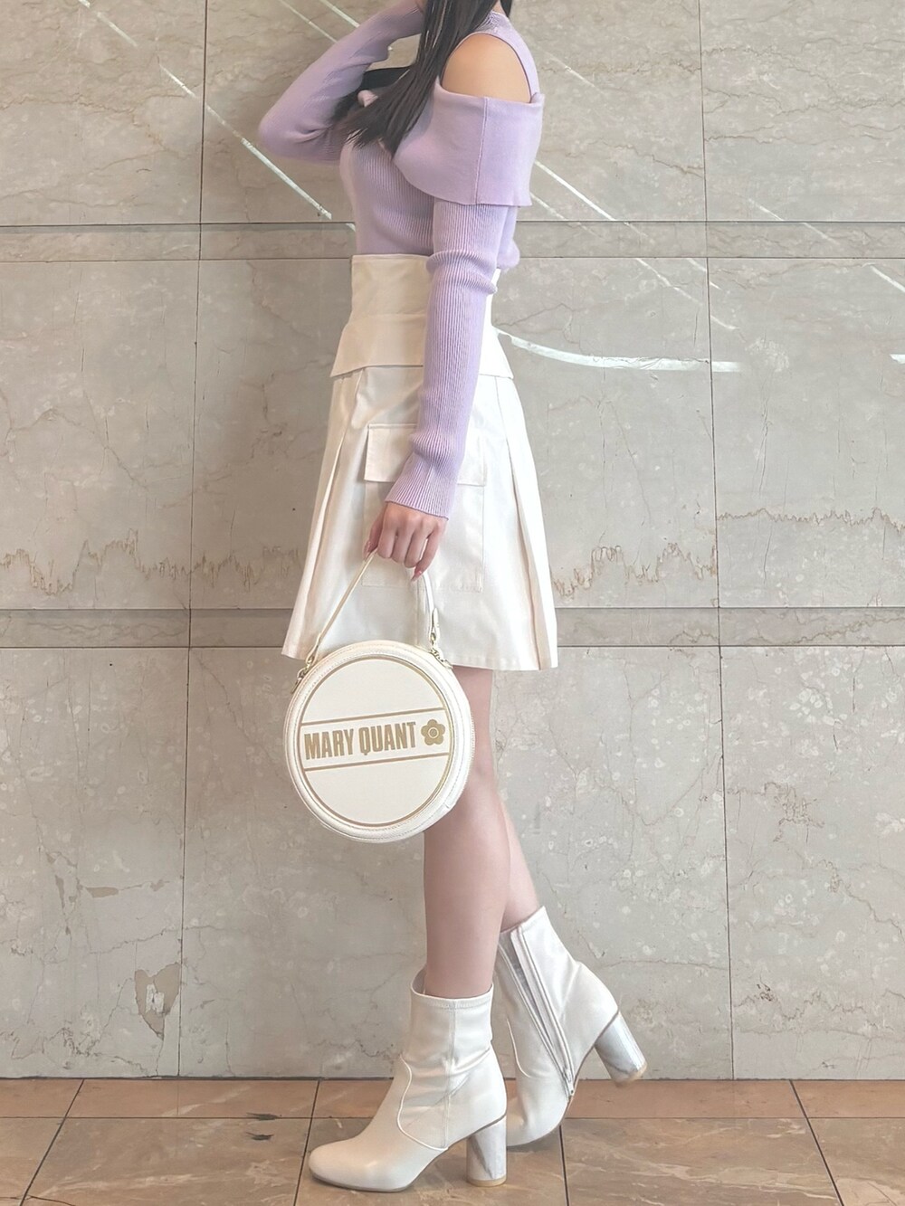 ホワイト系のショルダーバッグ、パープル系のニット/セーター、ホワイト系のスカートを着用したレディースの冬コーディネートの2枚目の写真