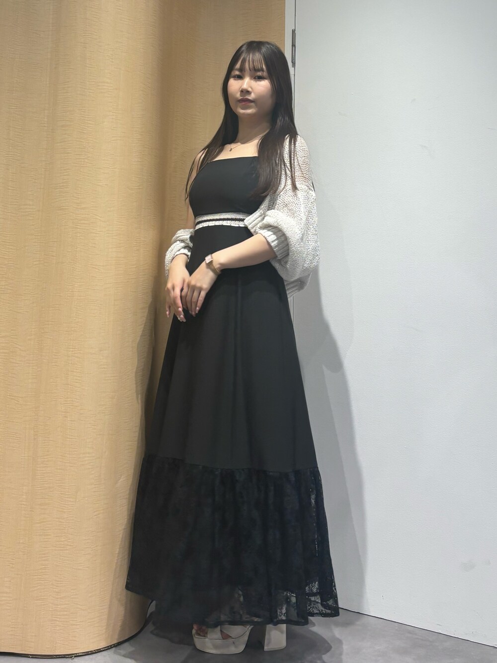 ブラック系のワンピース、ホワイト系のサンダル、ホワイト系のカーディガン/ボレロを着用したレディースの夏コーディネートの2枚目の写真