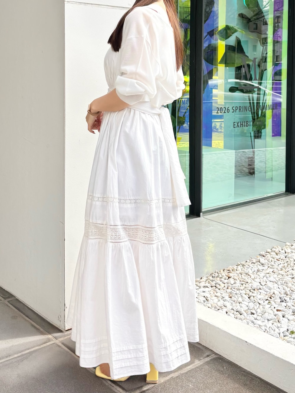 ホワイト系のワンピース、ホワイト系のカーディガン/ボレロ、イエロー系のサンダルを着用したレディースの春コーディネートの4枚目の写真