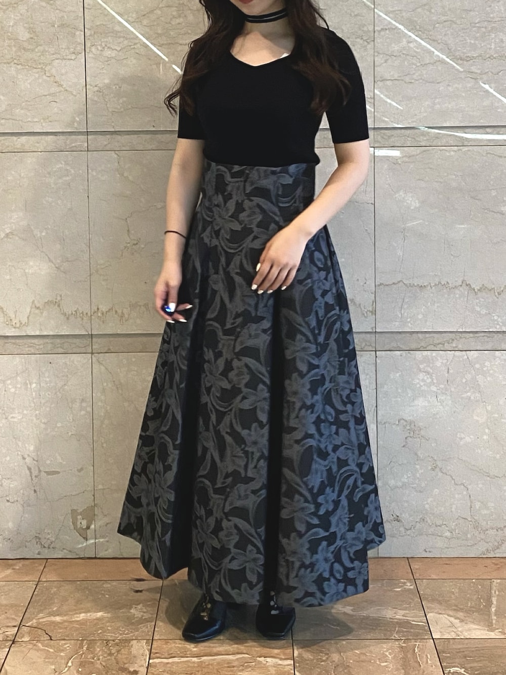 グレー系のスカート、ブラック系のブーツ、ホワイト系のニット/セーターを着用したレディースの秋コーディネートの3枚目の写真