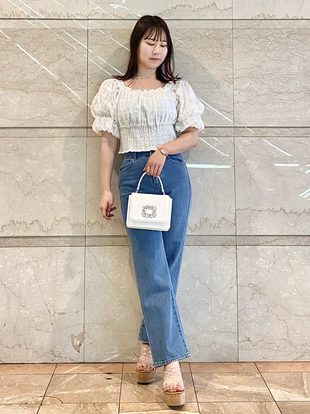 ホワイト系のショルダーバッグ、ホワイト系のシャツ/ブラウス、ブルー系のデニムパンツを着用したレディースの春コーディネートの3枚目の写真