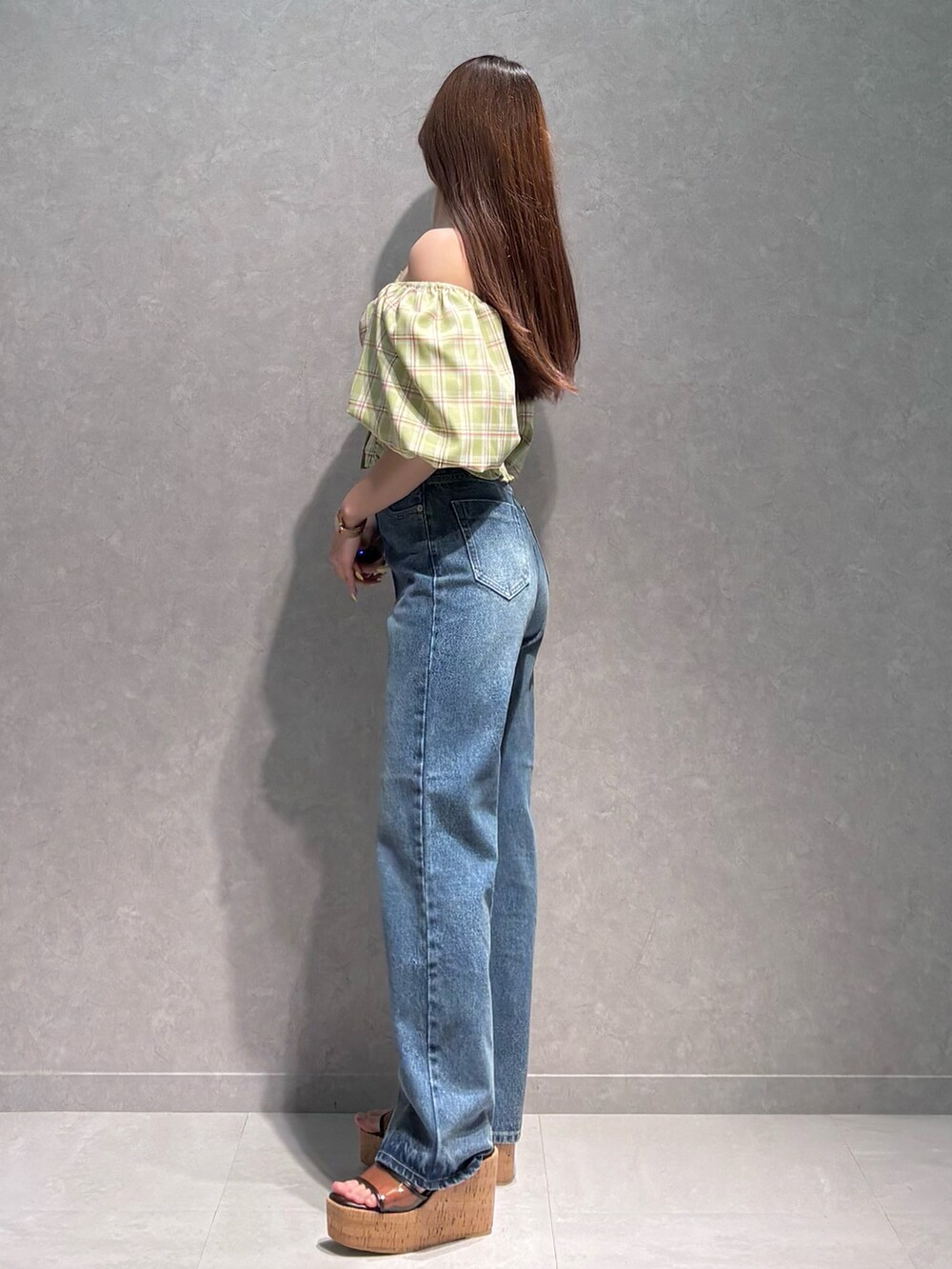 ブルー系のデニムパンツ、ブラウン系のサンダル、グリーン系のシャツ/ブラウスを着用したレディースの春コーディネートの4枚目の写真