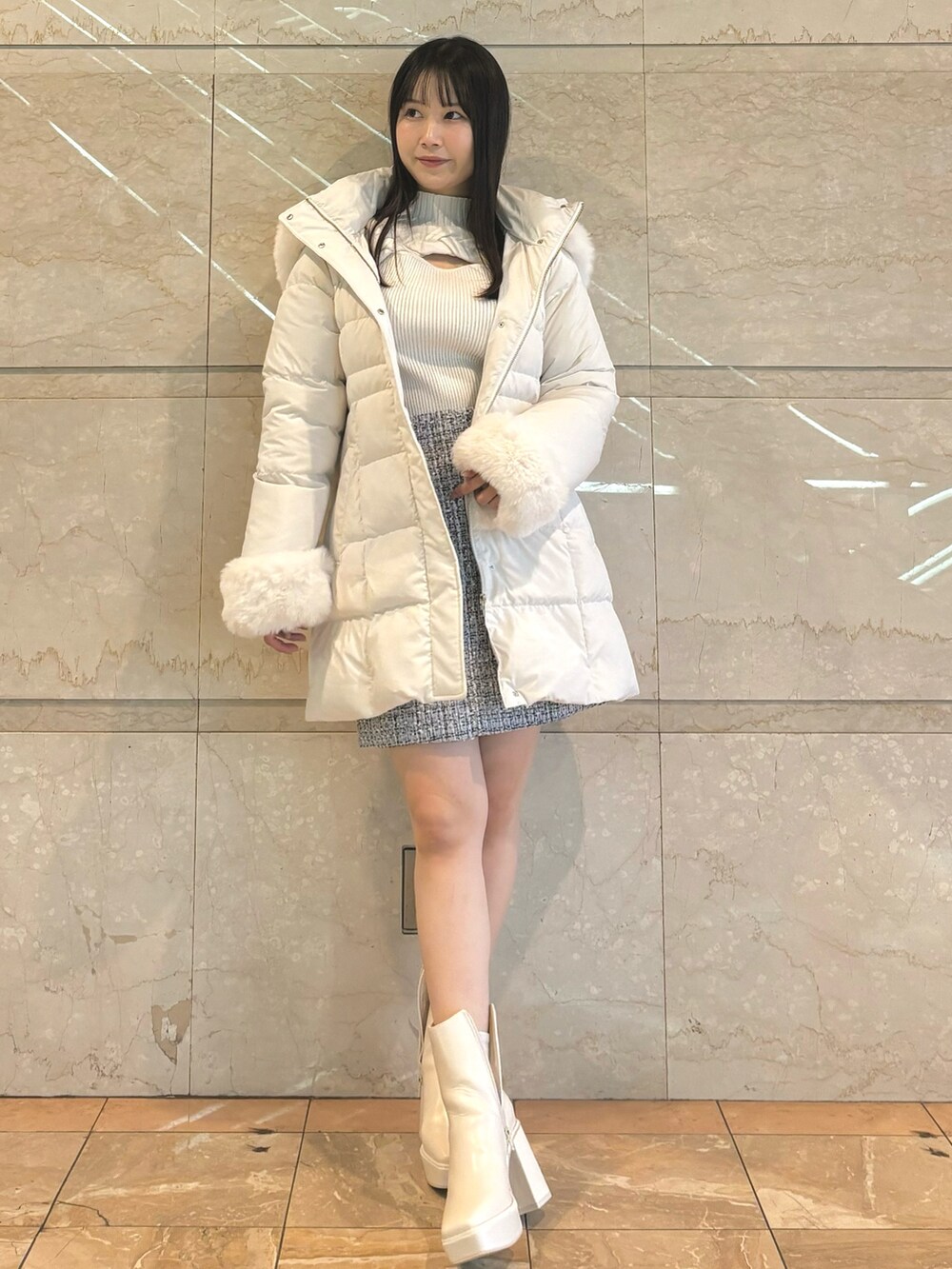 ホワイト系のダウンジャケット/コート、ホワイト系のブーツ、ホワイト系のスカートを着用したレディースの秋コーディネートの3枚目の写真