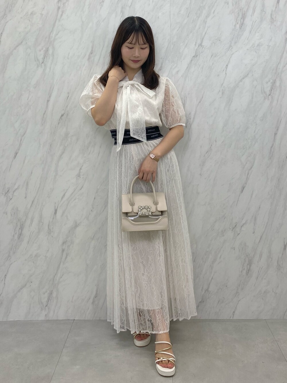 ベージュ系のショルダーバッグ、ホワイト系のサンダル、ホワイト系のシャツ/ブラウスを着用したレディースの夏コーディネートの2枚目の写真