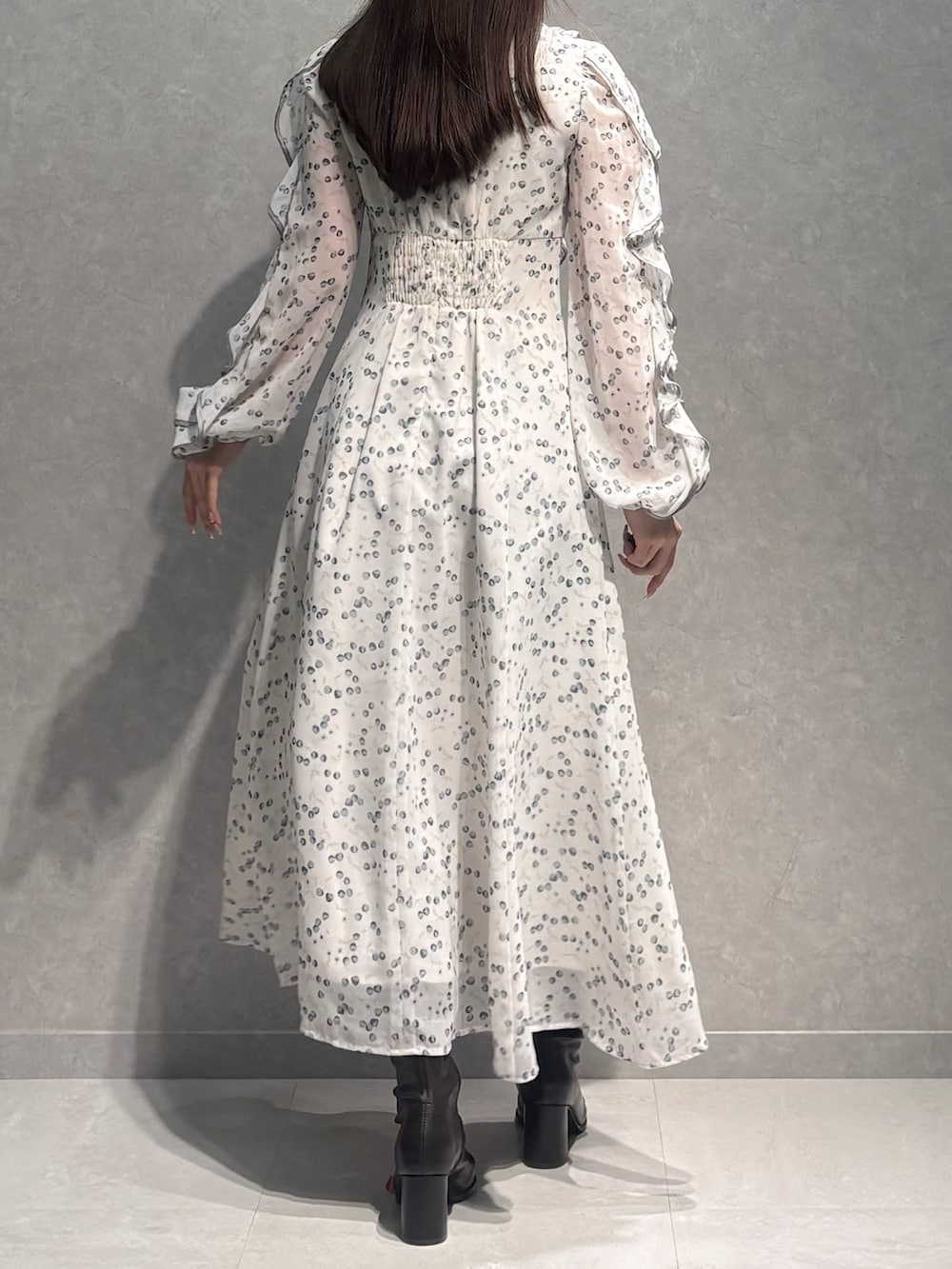 ホワイト系のワンピース、ブラウン系のブーツを着用したレディースの冬コーディネートの5枚目の写真