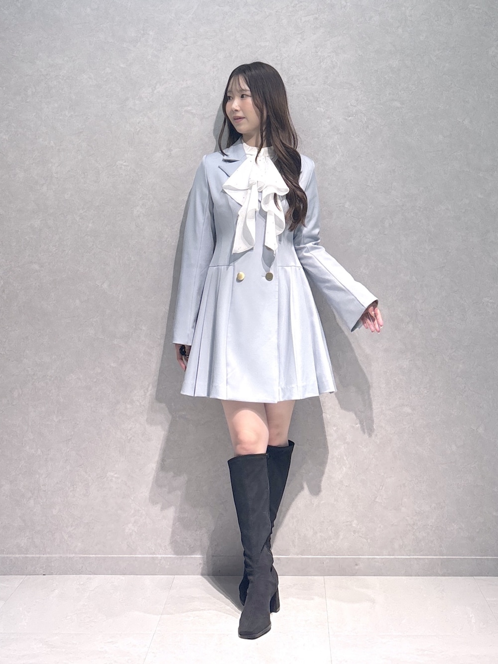 ブルー系のワンピース、ホワイト系のシャツ/ブラウス、ブラック系のブーツを着用したレディースの秋コーディネートの2枚目の写真