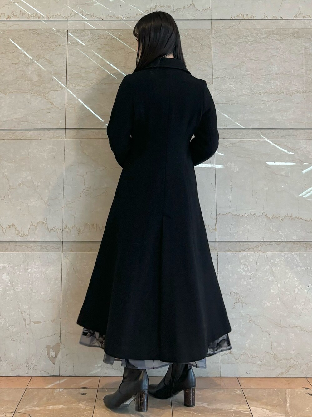 グレー系のスカート、ブラック系のその他アウター、ブラック系のニット/セーターを着用したレディースの冬コーディネートの3枚目の写真