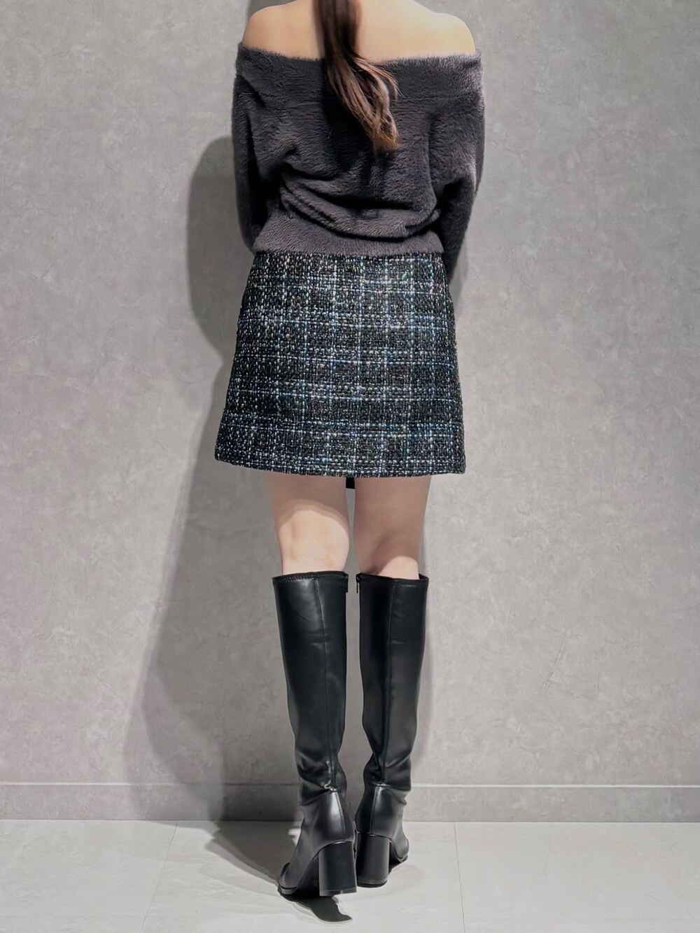 ブラック系のスカート、グレー系のニット/セーター、ブラック系のハンドバッグを着用したレディースの秋コーディネートの5枚目の写真