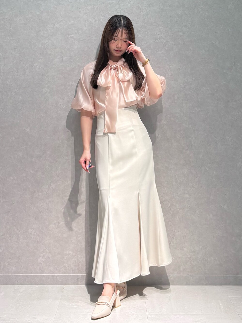 ホワイト系のスカート、ピンク系のシャツ/ブラウス、ホワイト系のパンプスを着用したレディースの春コーディネートの2枚目の写真