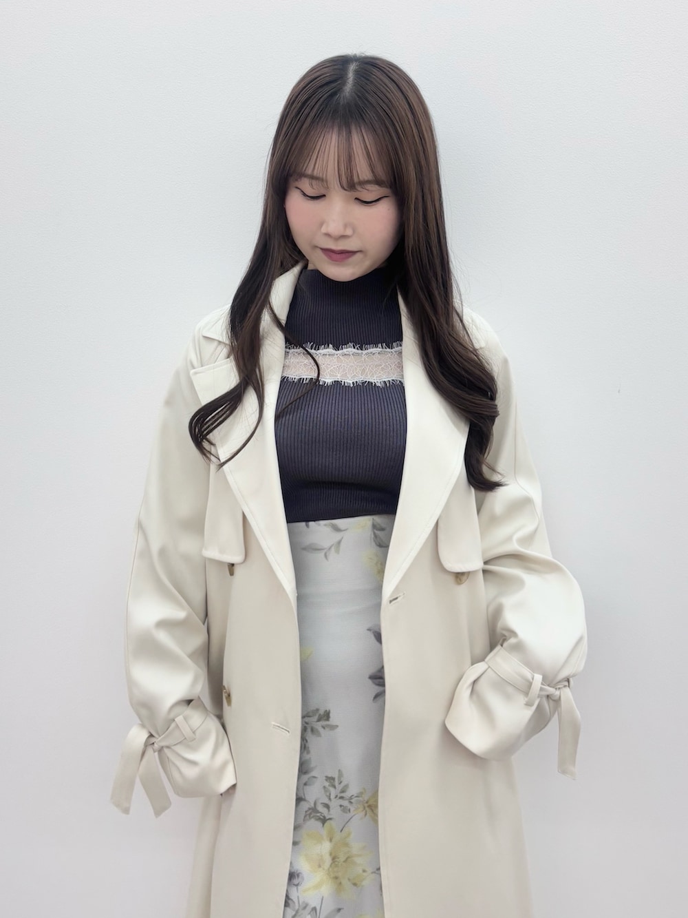 ブラック系のブーツ、グレー系のニット/セーター、ホワイト系のトレンチコートを着用したレディースの冬コーディネートの5枚目の写真