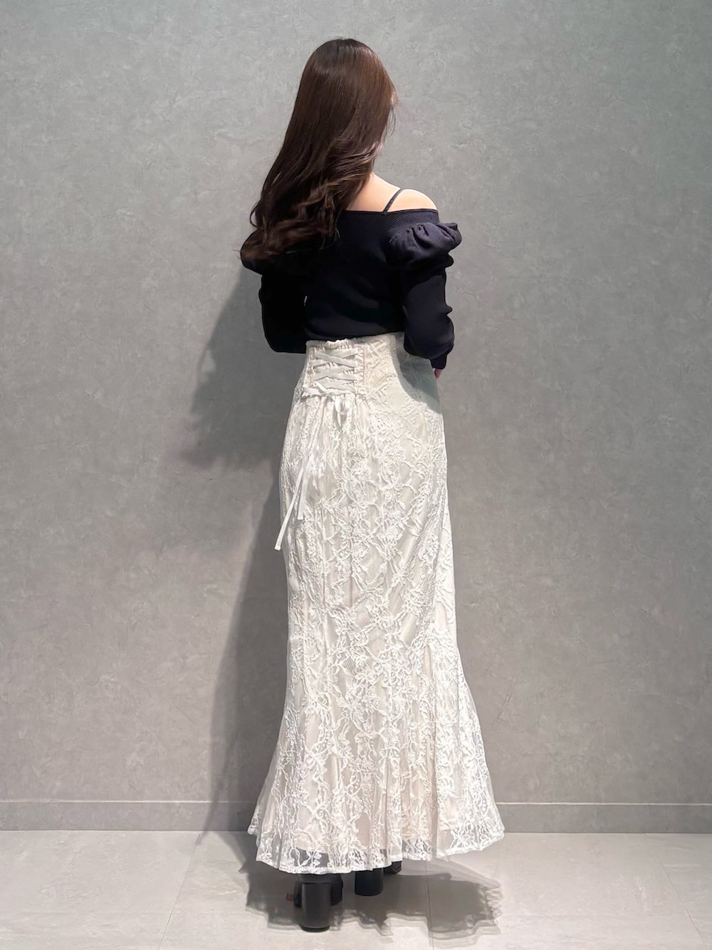 ホワイト系のスカート、ブルー系のニット/セーター、ブラウン系のブーツを着用したレディースの冬コーディネートの4枚目の写真